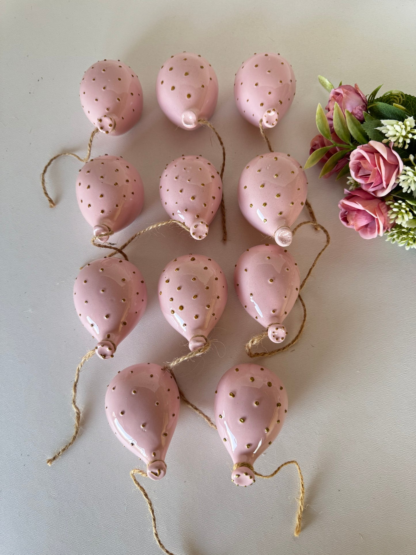 Un tocco di poesia sulle pareti: palloncino in ceramica rosa cipria con dettagli oro, per decorare con delicatezza.