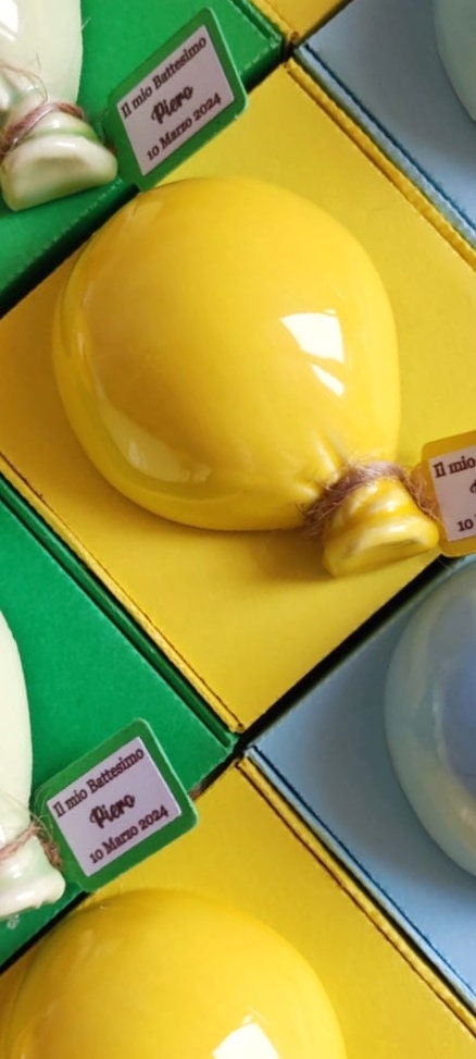 Calamita in ceramica smaltata a forma di palloncino, realizzata a mano per un tocco di artigianato autentico.