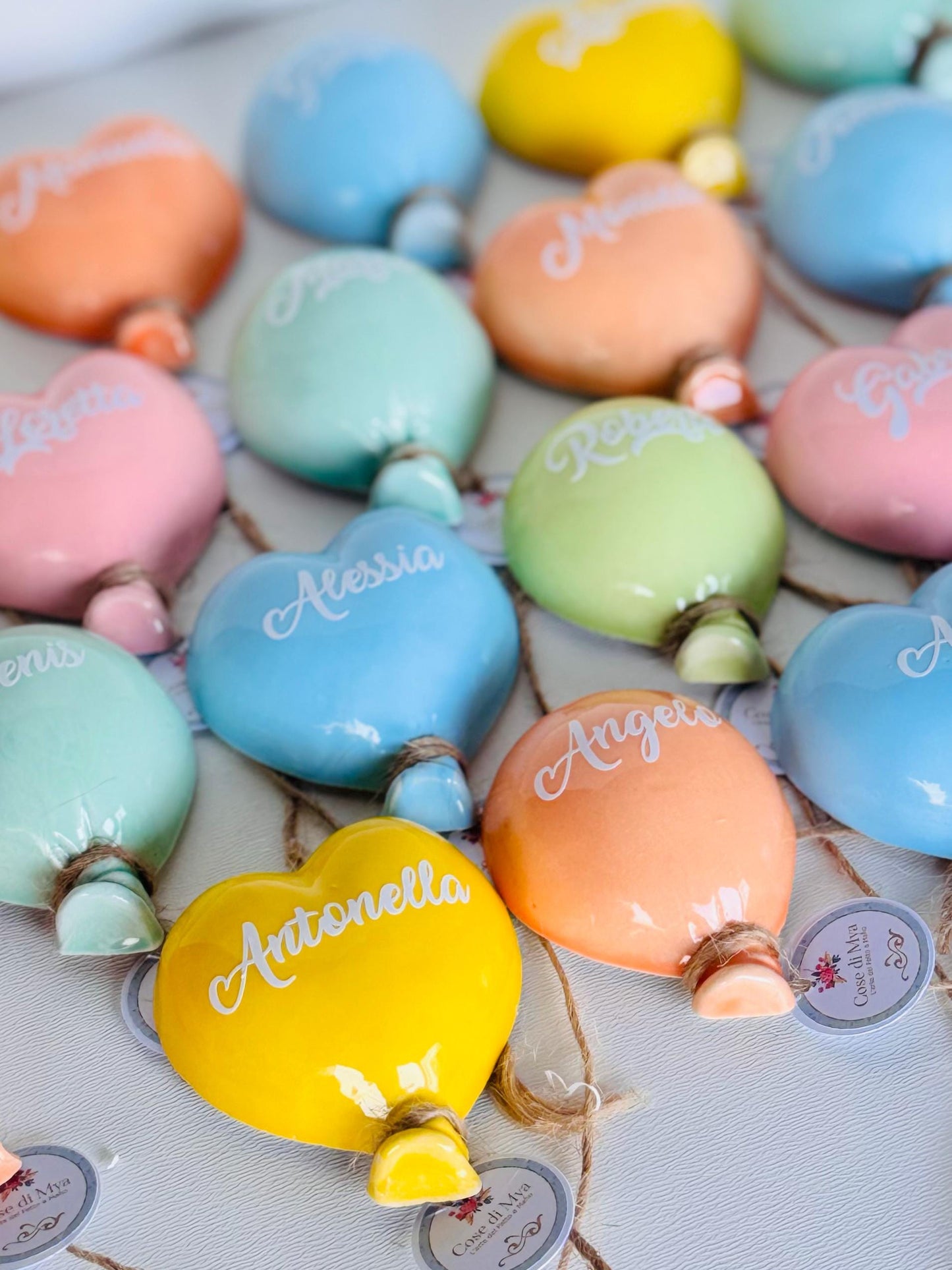 Calamita in ceramica artigianale a forma di palloncino, fatta a mano e dipinta con colori vivaci, ideale per decorare frigoriferi e superfici metalliche