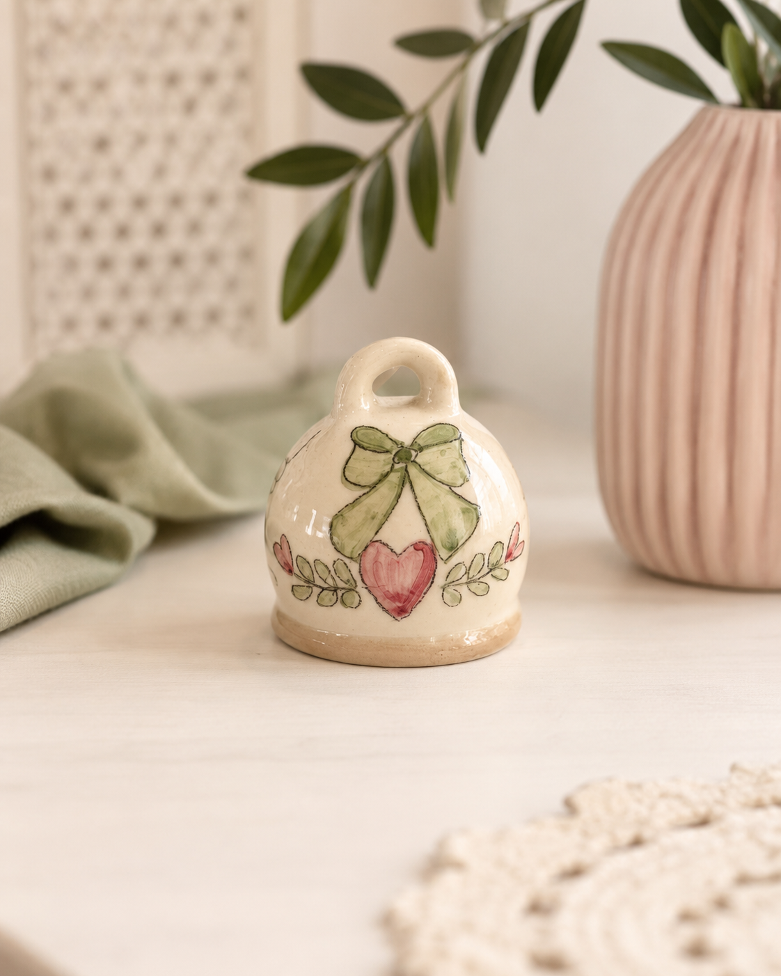 Un piccolo simbolo di affetto da custodire nel tempo. La Campanella Capri è realizzata in ceramica smaltata e decorata con un delicato fiocco verde e un cuore rosa. Perfetta come bomboniera, idea regalo o decorazione per la casa, può essere personalizzata per rendere ancora più speciale ogni occasione.