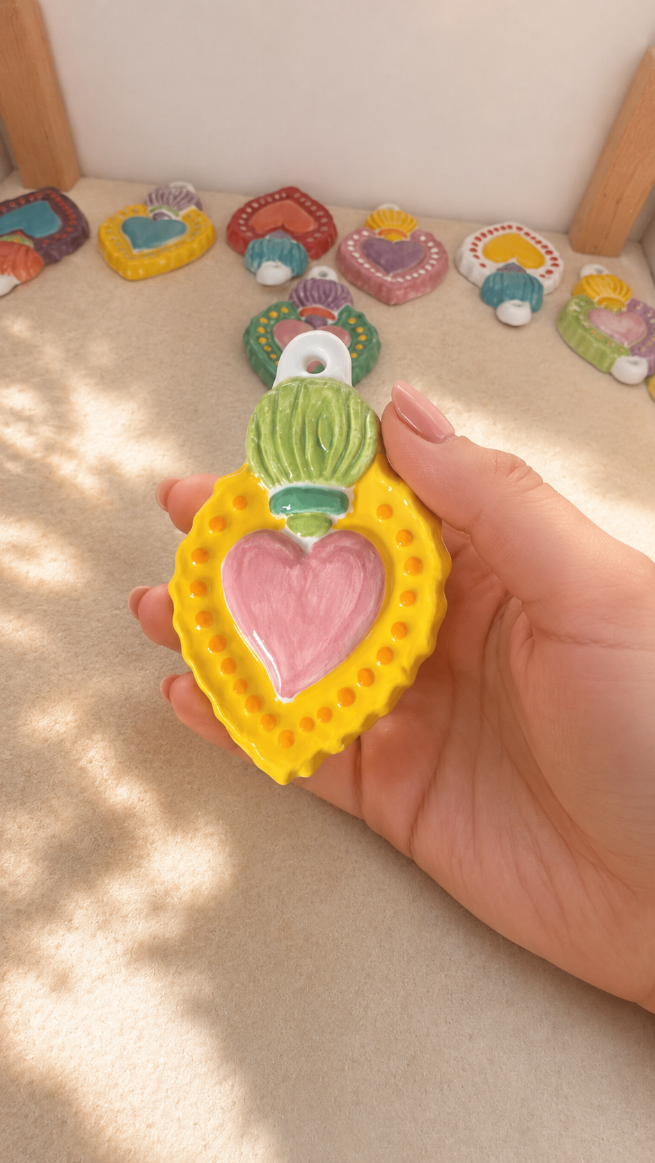 Particolare del Sacro Cuore in ceramica decorato nei toni del rosa, verde e giallo.
