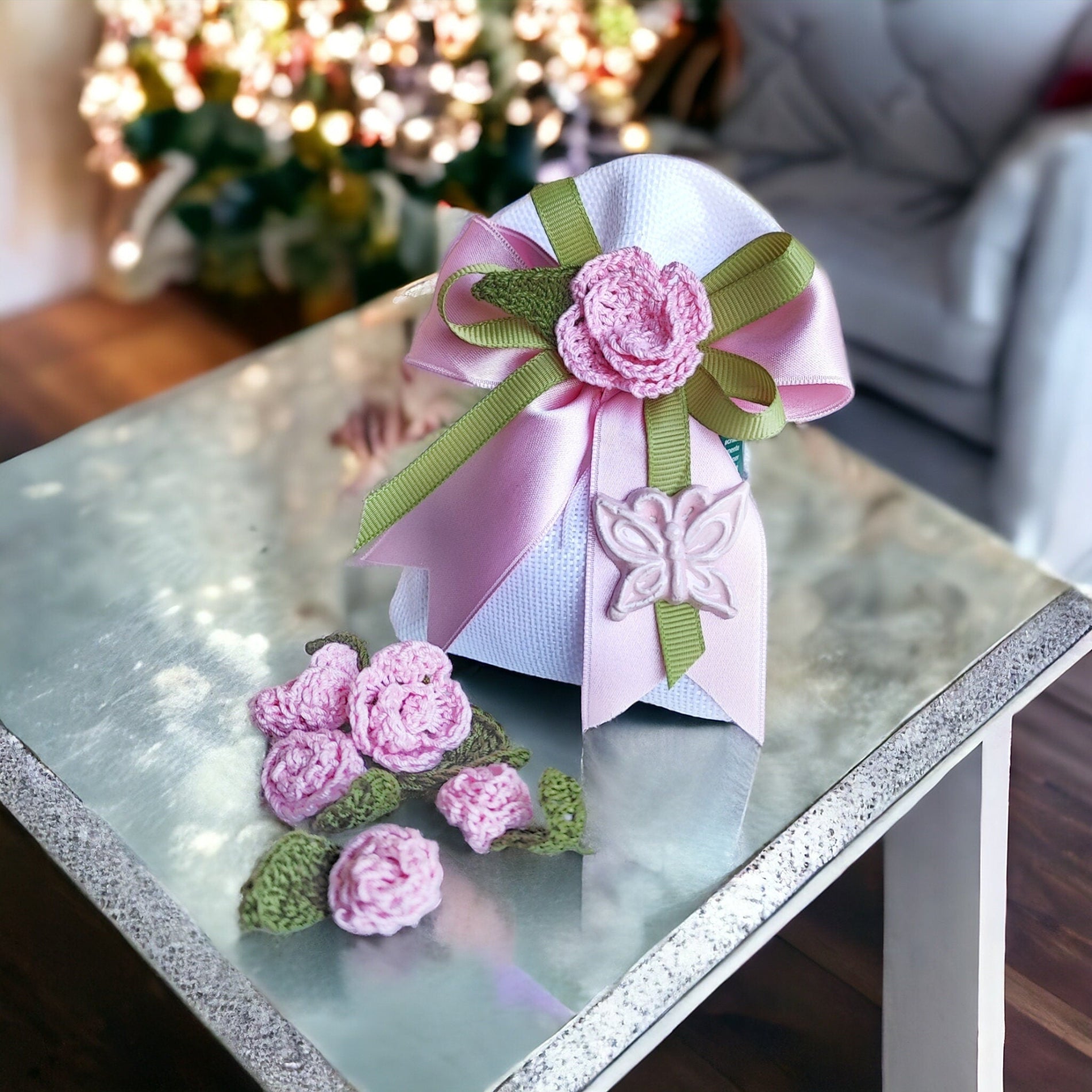 Sacchetto artigianale decorato con fiori all'uncinetto e farfallina in ceramica.