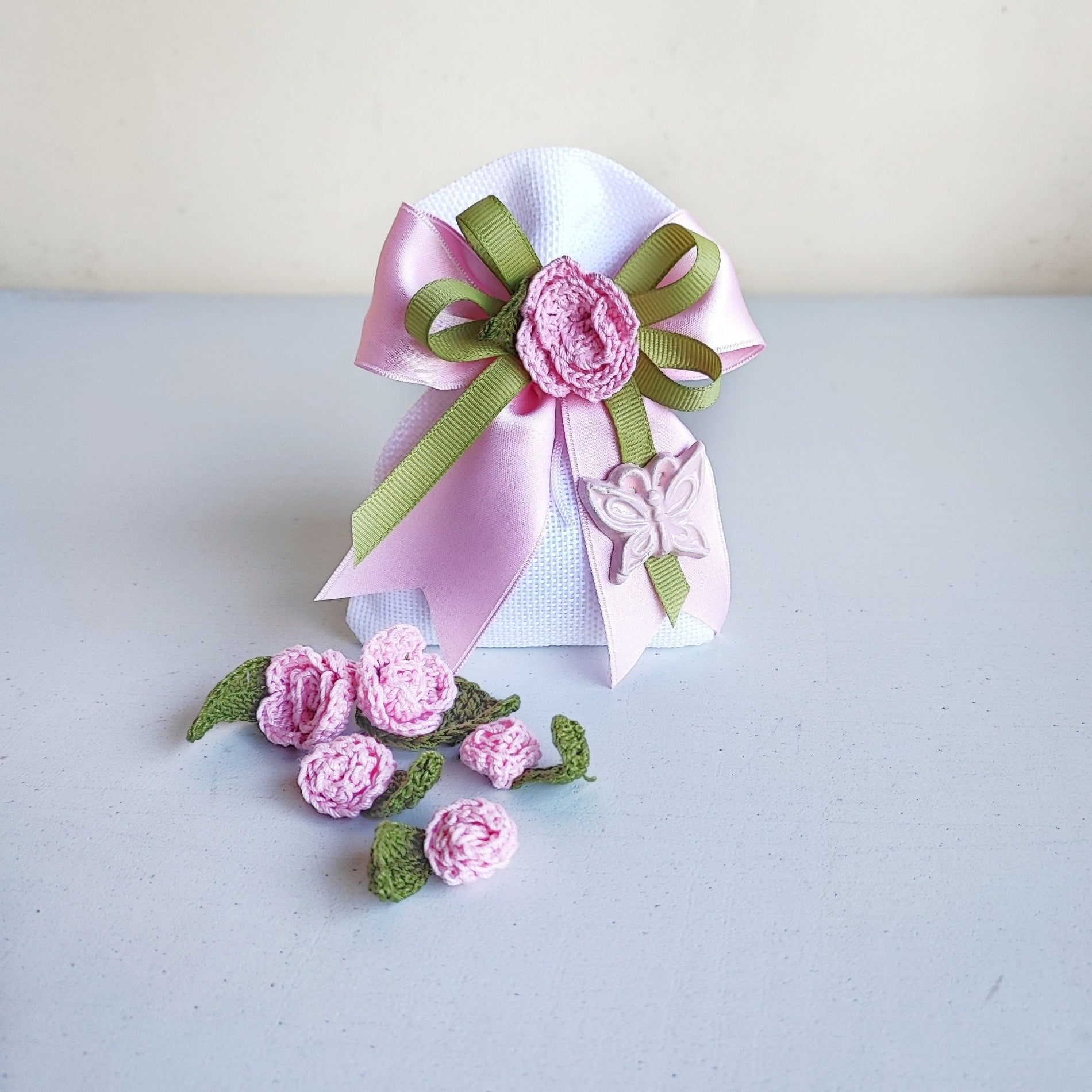 Sacchetto decorato con fiori fatti a mano e farfallina in ceramica, ideale come bomboniera.
